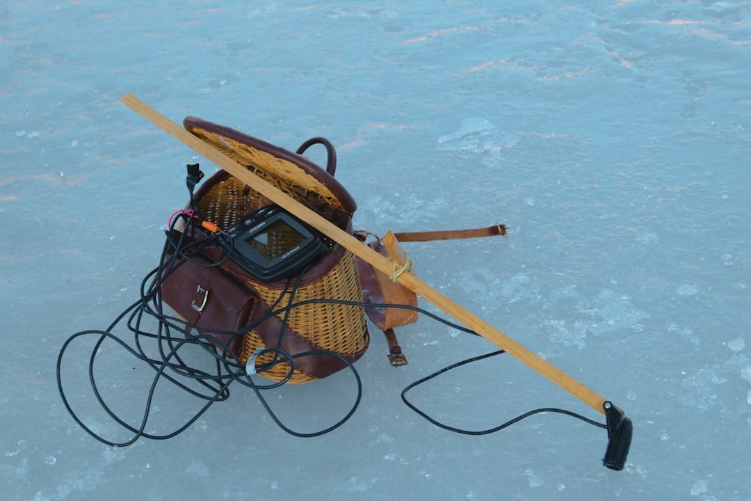 Arctic survival gear laid out on snow including emergency beacon, thermal blankets, headlamp, and insulated equipment